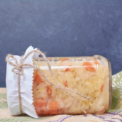 Sauerkraut In Glass Jar On Blue Background With Tablecloth