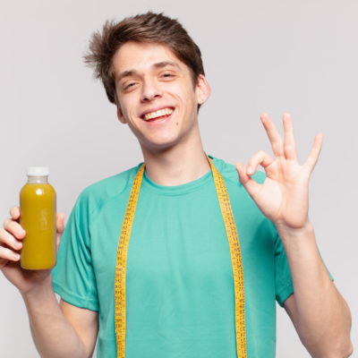 Young Teenager Man Happy Expression And Holding A Soothy. Diet Concept